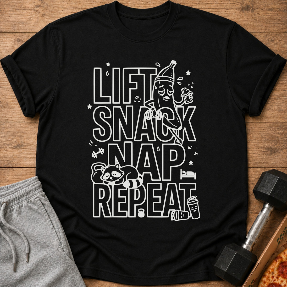 Black t-shirt with white text "Lift Snack Nap Repeat" and cartoon graphics.