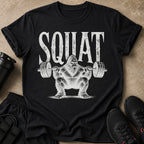 Black t-shirt with white text "SQUAT" and a Bigfoot lifting a barbell.