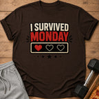 Brown t-shirt with text "I survived Monday" and pixelated hearts.