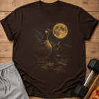 Brown t-shirt with a goose and moon graphic, next to grey shorts and a dumbbell.