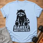 Light blue t-shirt with black graphic of raccoon holding weights and text "RARELY MOTIVATED".