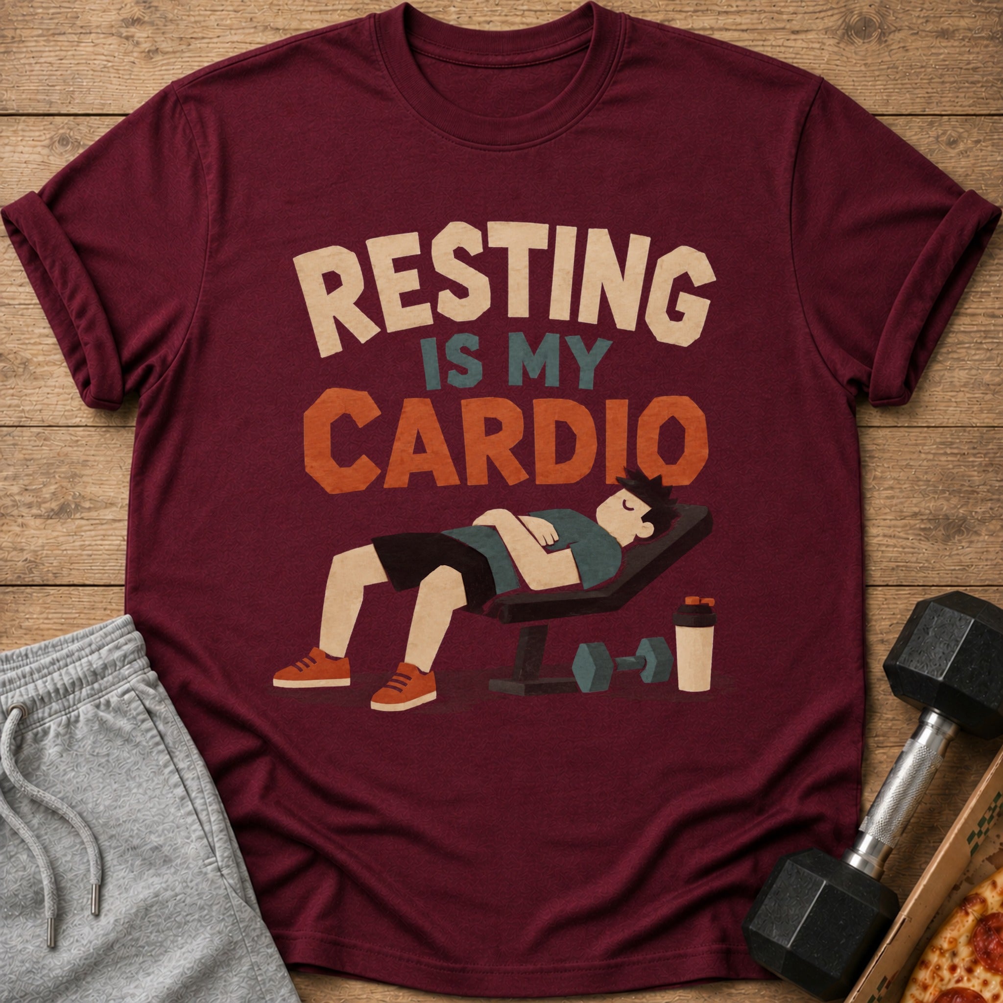 Maroon t-shirt with text "RESTING IS MY CARDIO" and a man sleeping on a bench.