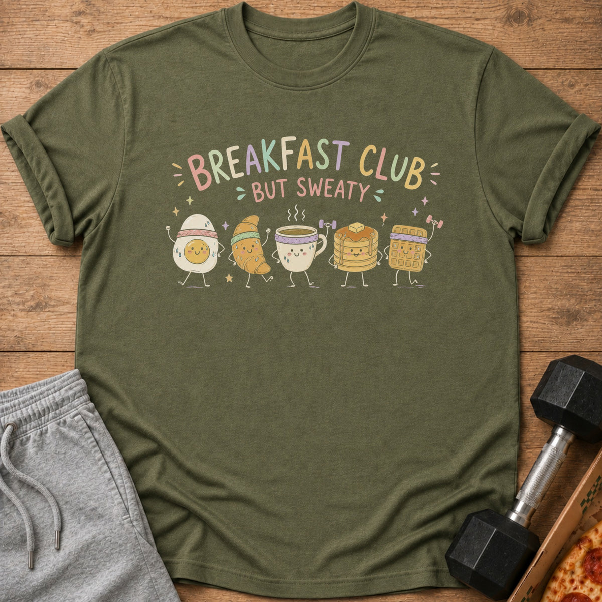 Olive green t-shirt with "Breakfast Club but Sweaty" text and cartoon breakfast foods.