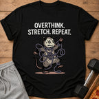 Black t-shirt with "Overthink. Stretch. Repeat." text and a tangled possum illustration.