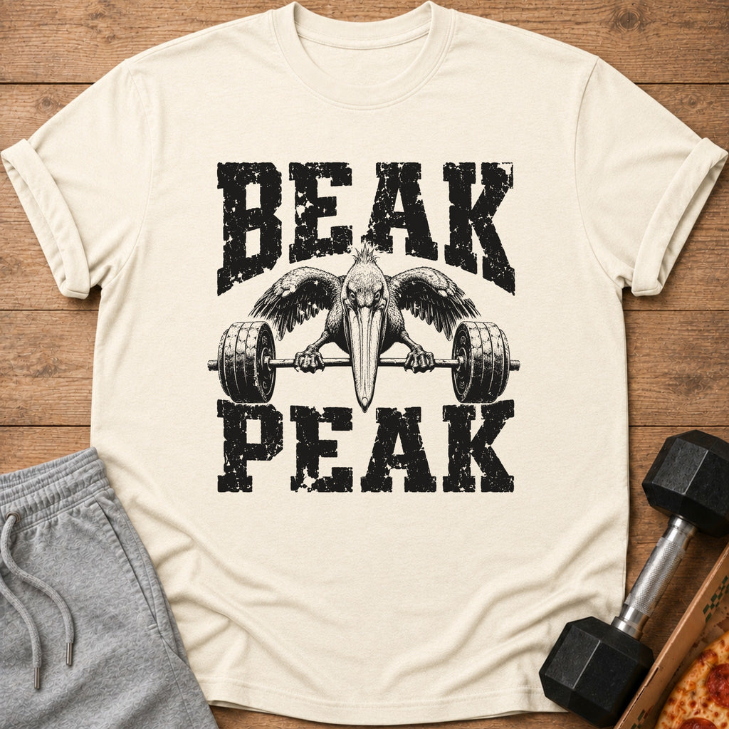 Cream t-shirt with black distressed text "BEAK PEAK" and a pelican lifting a barbell.