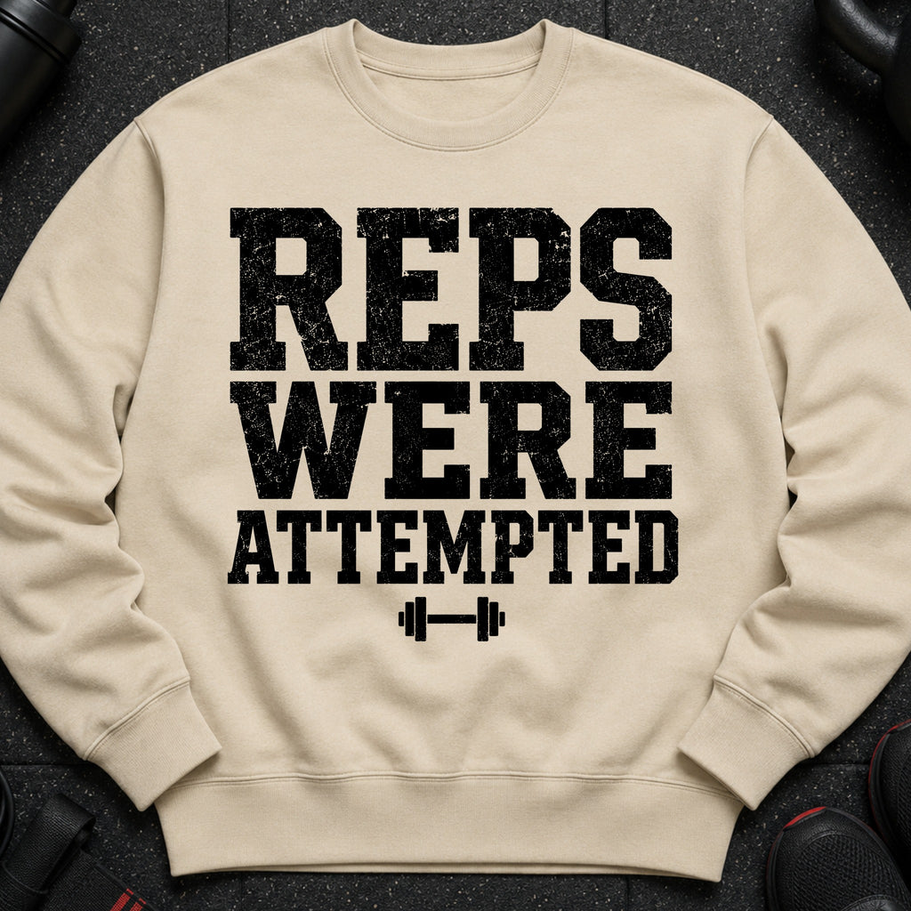 Beige sweatshirt with black distressed text "REPS WERE ATTEMPTED" and dumbbell graphic.