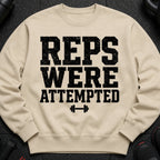 Beige sweatshirt with black distressed text "REPS WERE ATTEMPTED" and dumbbell graphic.