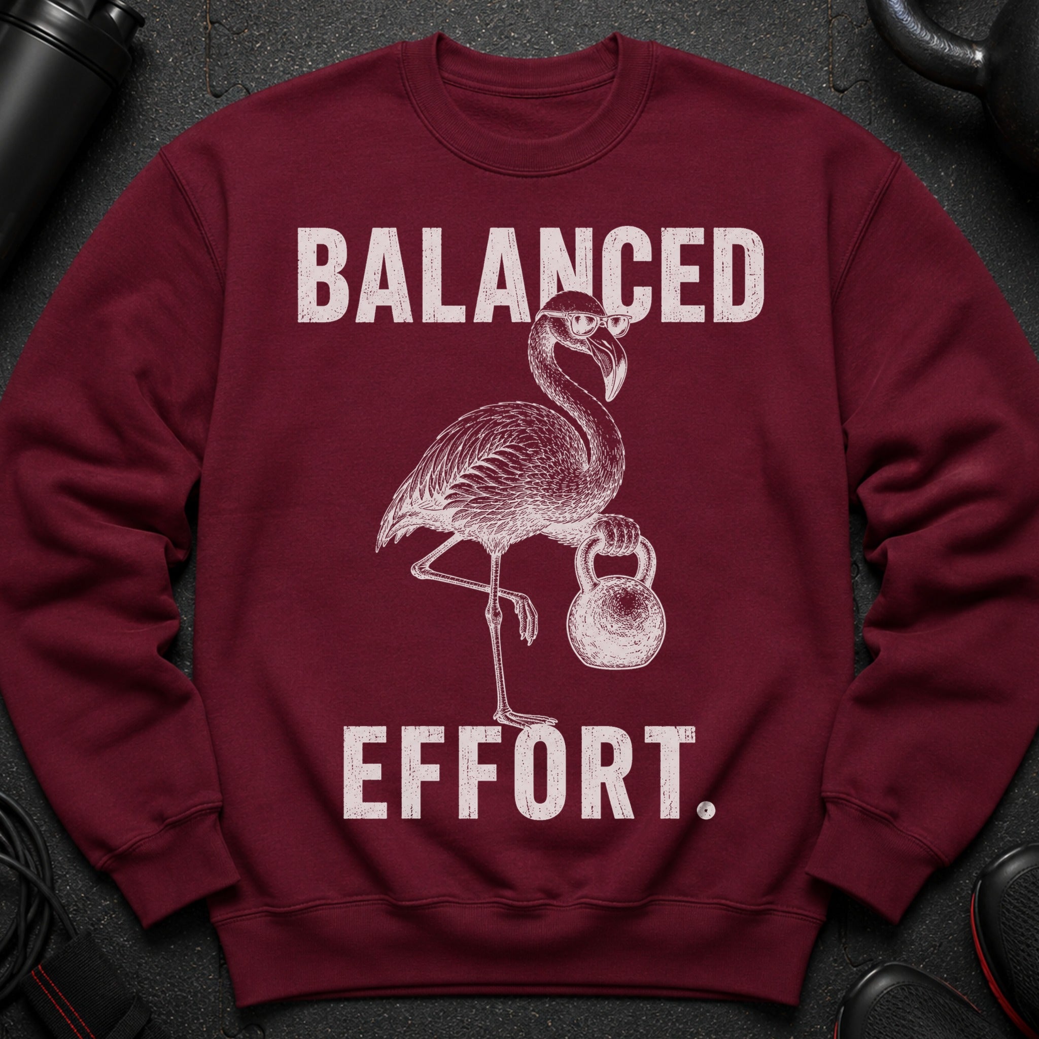 Maroon sweatshirt with a flamingo lifting a kettlebell and text "BALANCED EFFORT."