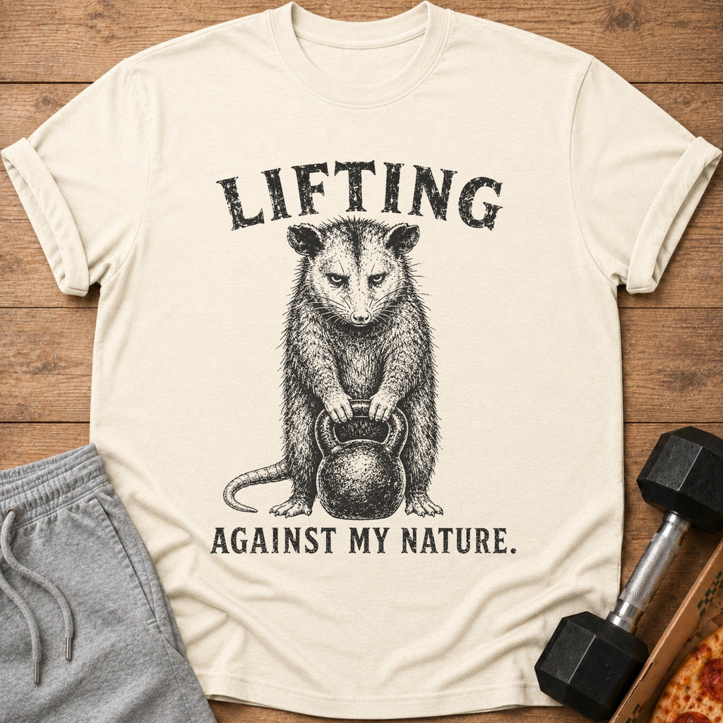 T-shirt with a possum lifting a kettlebell and text "LIFTING AGAINST MY NATURE."