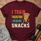 Maroon t-shirt with text "I train therefore I require snacks" and cartoon pizza character lifting weights.