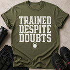 Olive green t-shirt with distressed white text "TRAINED DESPITE DOUBTS" and a kettlebell graphic.