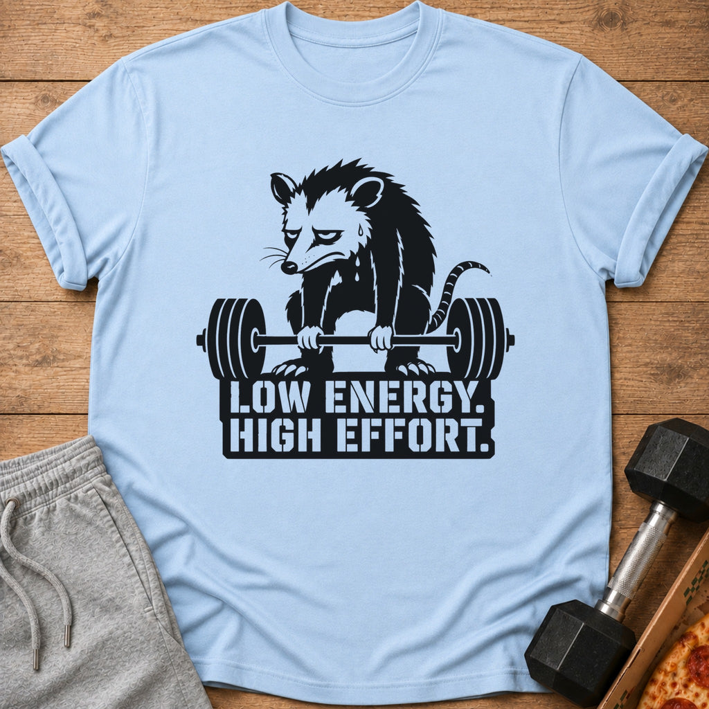 Light blue t-shirt with a sad possum lifting a barbell, text reads "LOW ENERGY. HIGH EFFORT."