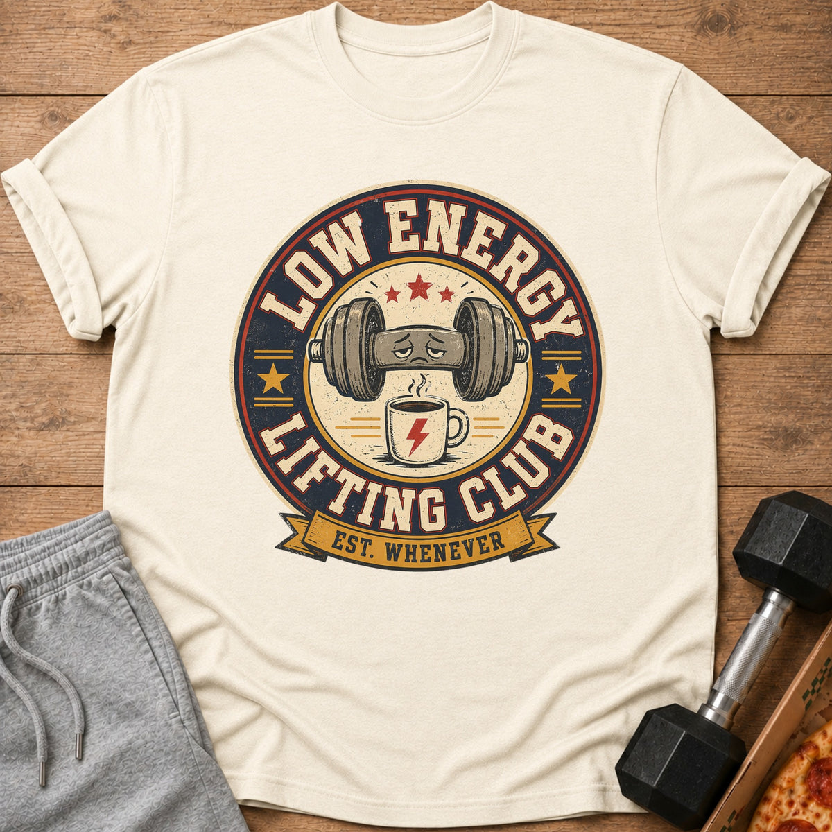 Cream t-shirt with "Low Energy Lifting Club Est. Whenever" graphic featuring a sad dumbbell and coffee.