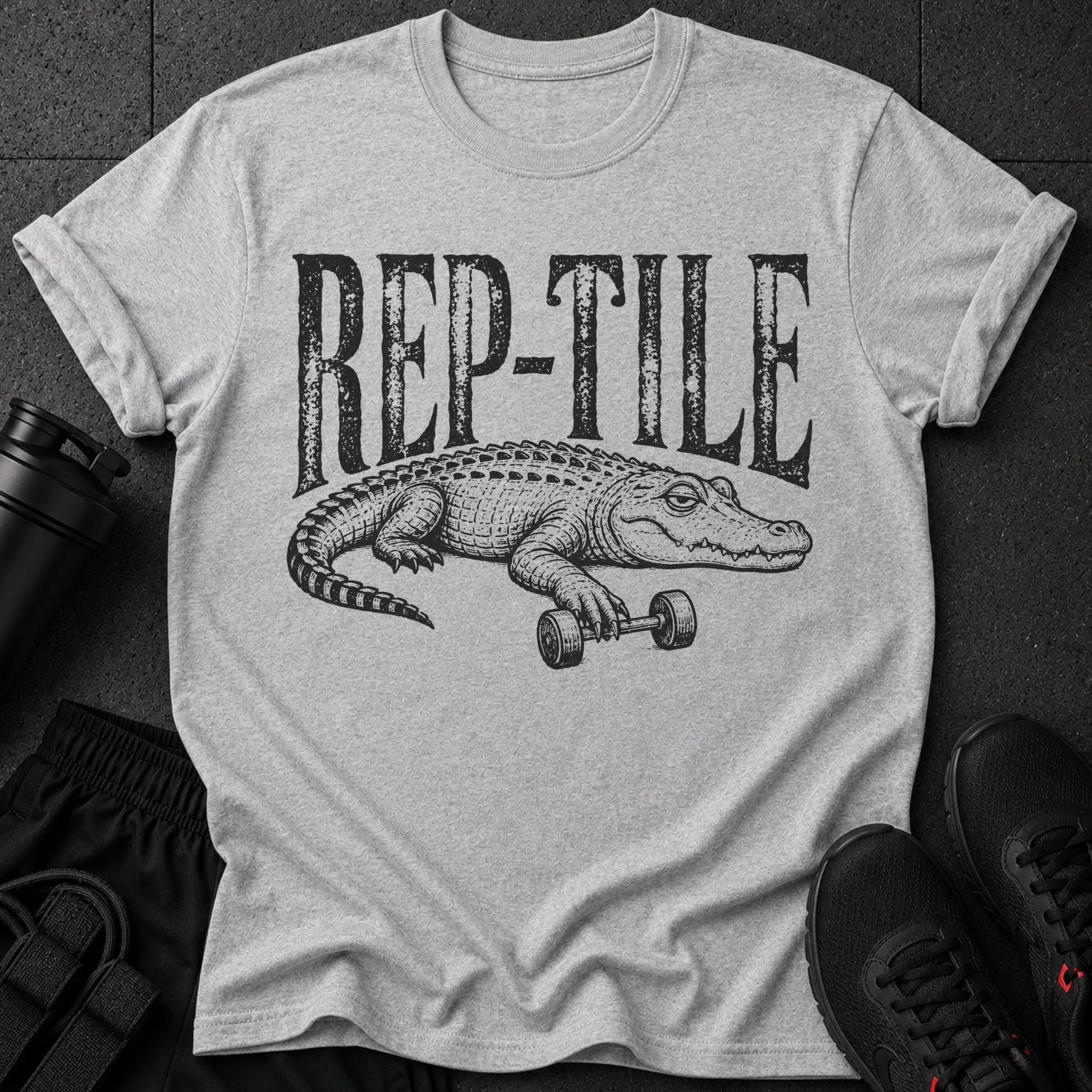 Grey t-shirt with black graphic text "REP-TILE" and a crocodile lifting a barbell.