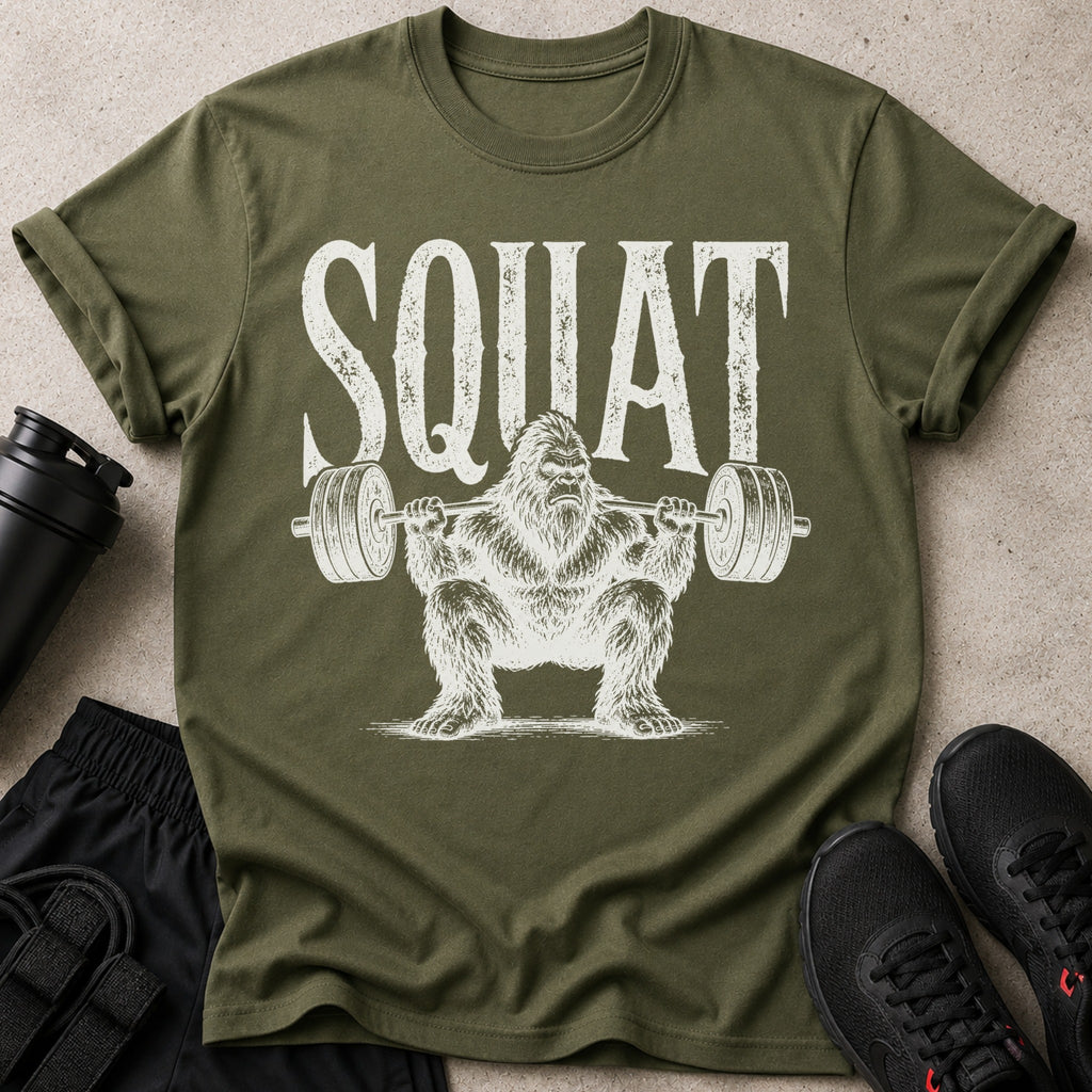 Military green t-shirt with distressed white "SQUAT" text and Bigfoot lifting weights.