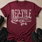 Maroon t-shirt with distressed "REP-TILE" text and an alligator lifting a dumbbell.