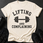 Cream t-shirt with black distressed text and a barbell graphic.