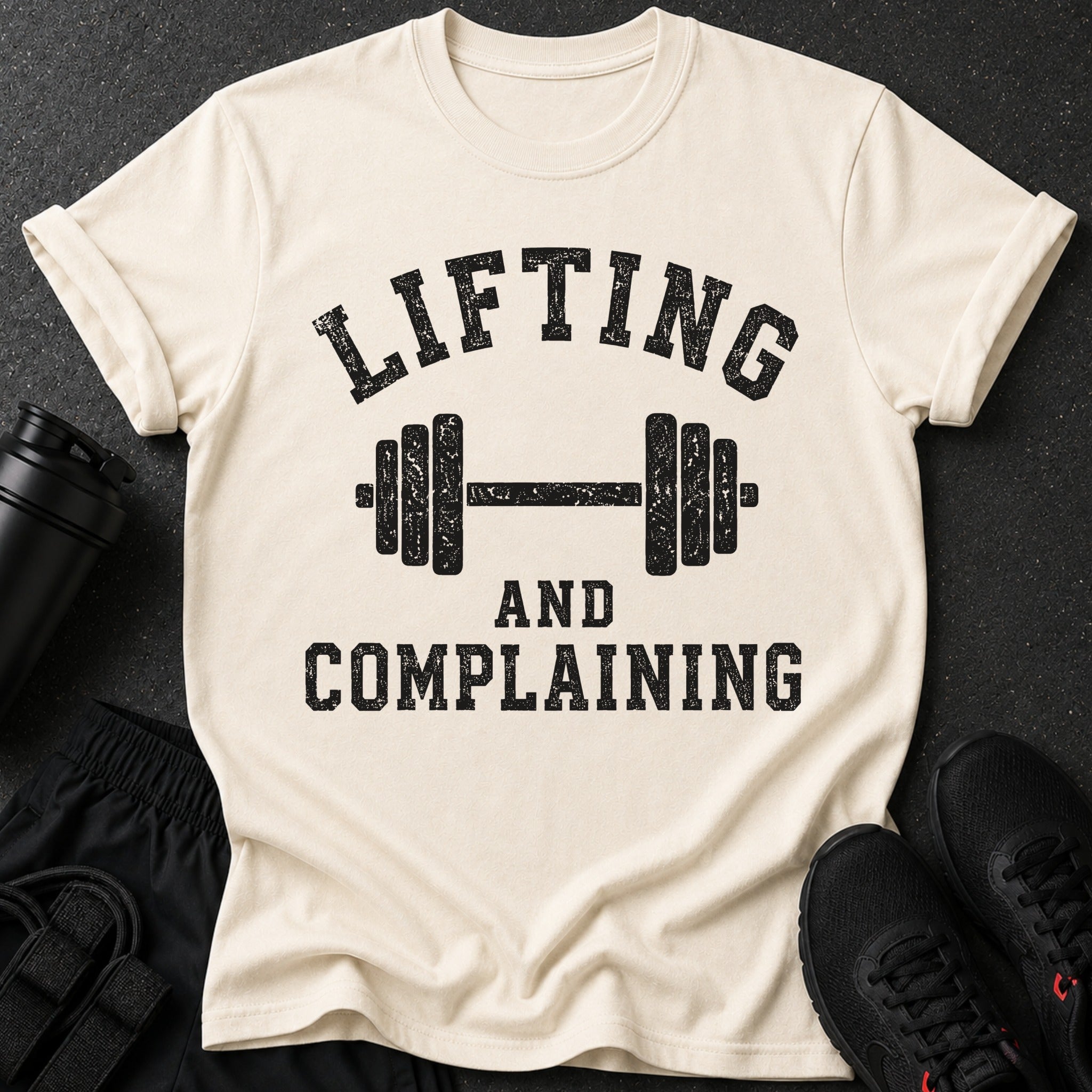 Cream t-shirt with black distressed text and a barbell graphic.
