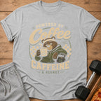 Gray t-shirt graphic of a bear holding coffee and text "POWERED BY COFFEE & REGRET".