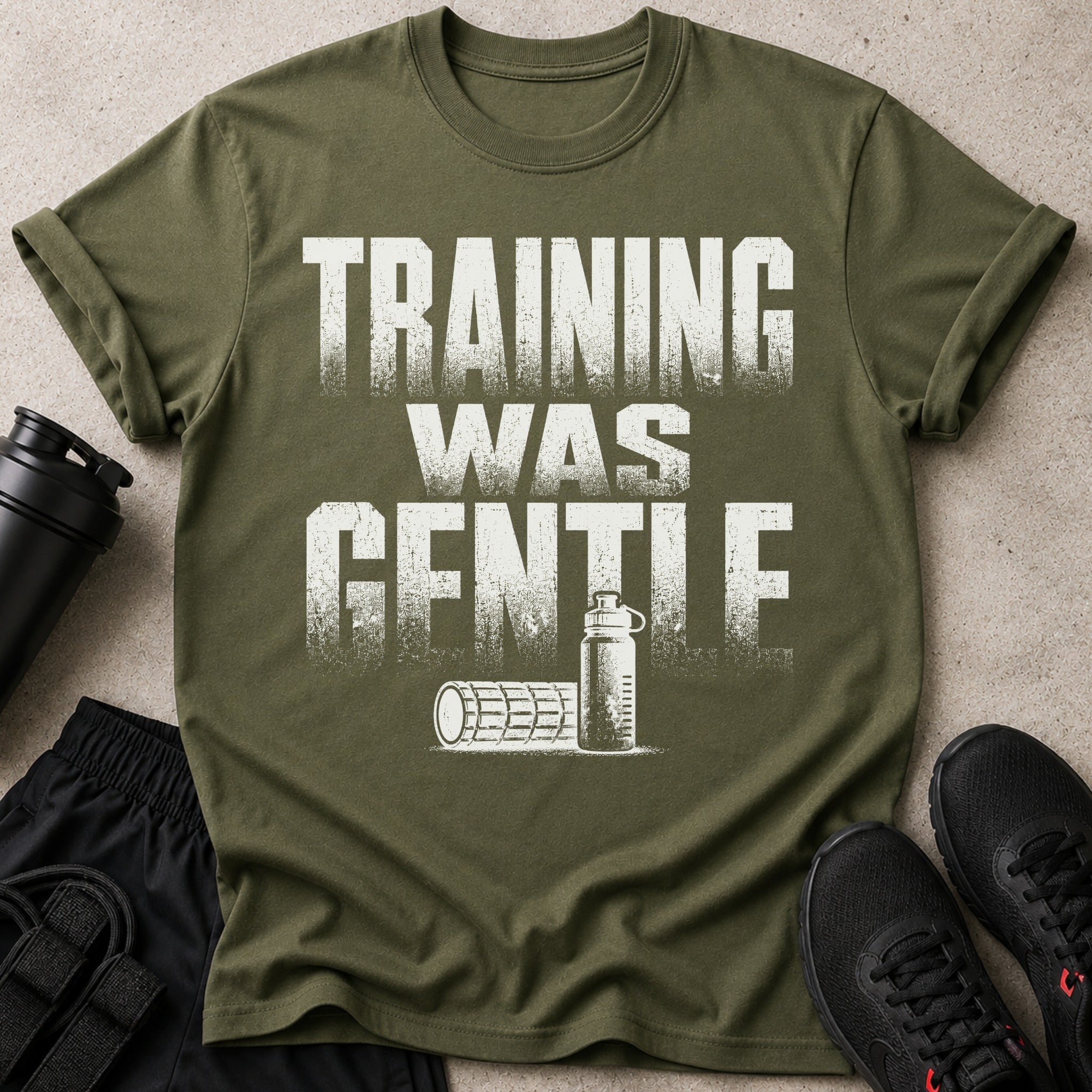 Olive green t-shirt with "TRAINING WAS GENTLE" graphic, water bottle, foam roller, shorts and shoes.