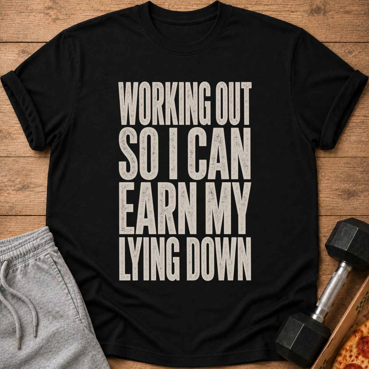 Black t-shirt with white text reading "WORKING OUT SO I CAN EARN MY LYING DOWN".