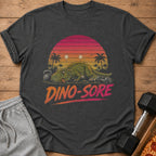 T-shirt with a tired dinosaur next to weights and dumbbells, text says "DINO-SORE".