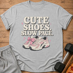 Gray t-shirt with pink and white sneakers and text "CUTE SHOES. SLOW PACE."