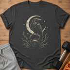 Dark t-shirt with raven perched on kettlebell under crescent moon and stars.