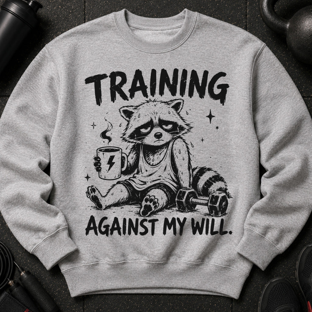 Grey crewneck sweatshirt with cartoon raccoon holding coffee, text "TRAINING AGAINST MY WILL."