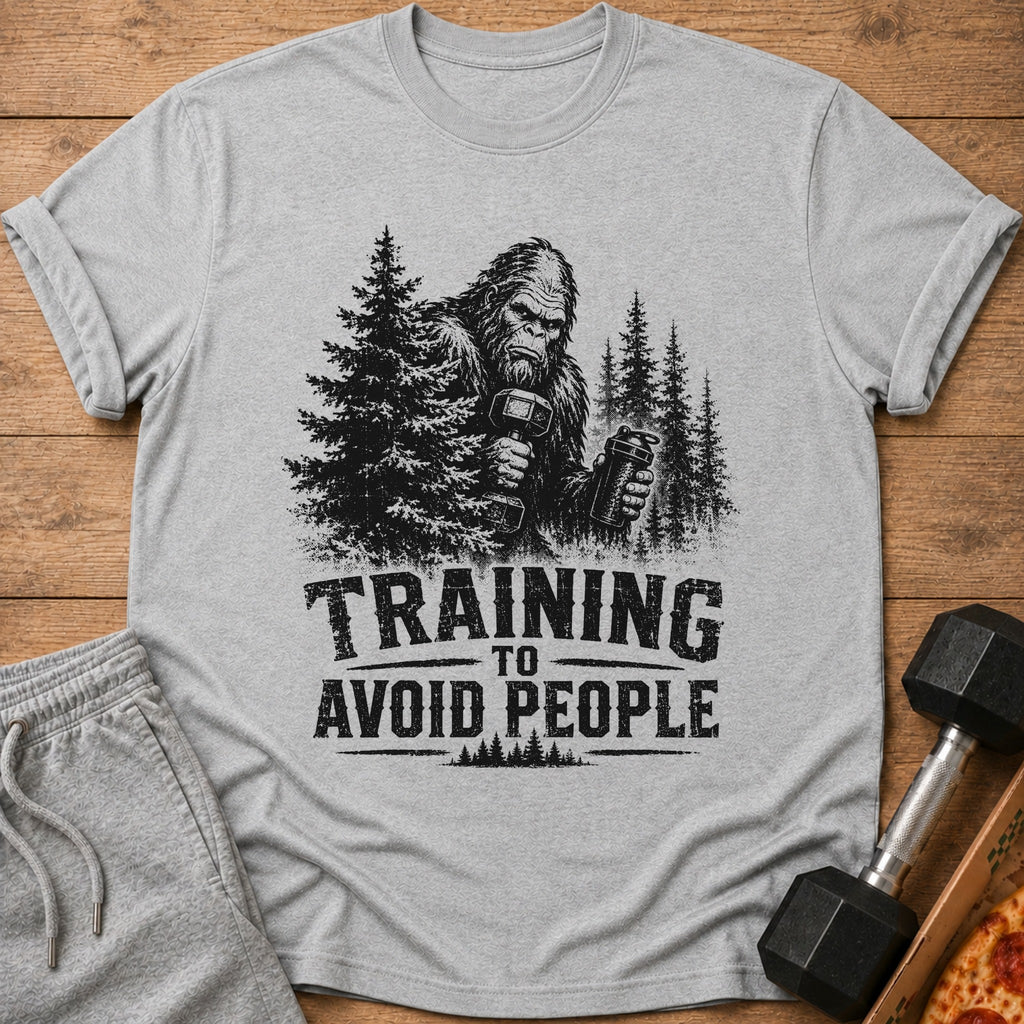Bigfoot holding a dumbbell and shaker on a t-shirt with "Training to Avoid People".