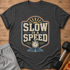 Dark grey t-shirt with "SLOW IS A SPEED" graphic and stopwatch.