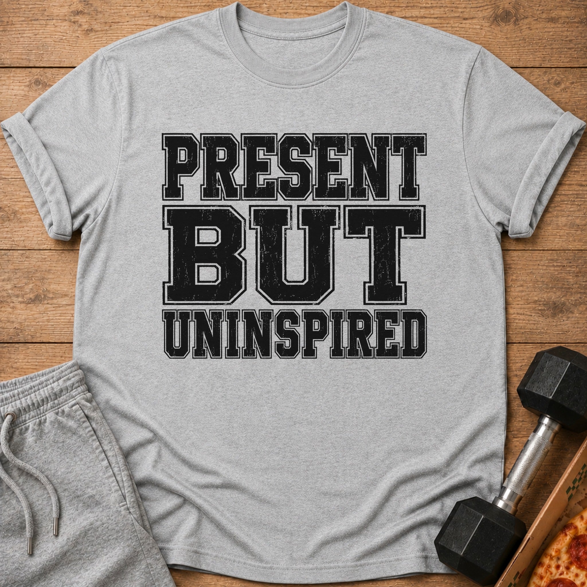 Grey t-shirt with distressed black text: PRESENT BUT UNINSPIRED.
