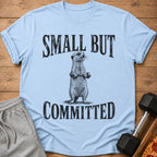 Light blue t-shirt with a meerkat lifting weights and text "SMALL BUT COMMITTED".