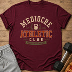 Maroon t-shirt with "Mediocre Athletic Club" and "Proudly Below Average" text.