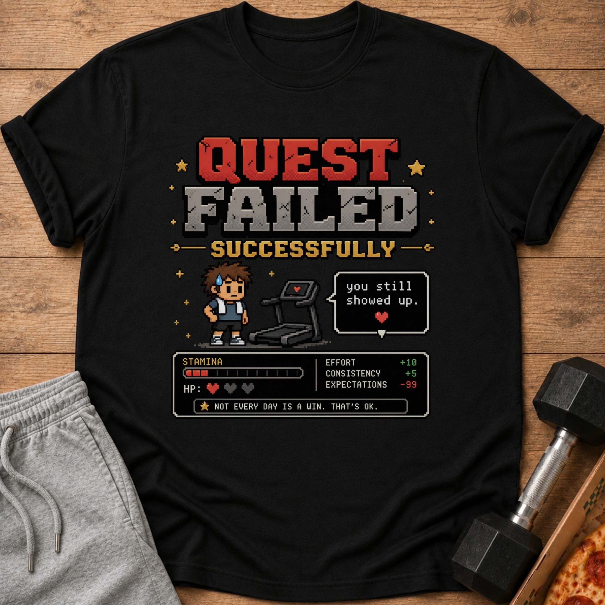 Black t-shirt with pixelated "QUEST FAILED SUCCESSFULLY" and workout stats.