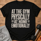A black t-shirt printed with the text AT THE GYM PHYSICALLY AT HOME EMOTIONALLY.