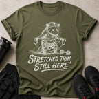 Olive green t-shirt with a distressed graphic of a raccoon exercising.