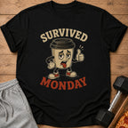 Black t-shirt with cartoon coffee cup saying "Survived Monday" and giving a thumbs up.