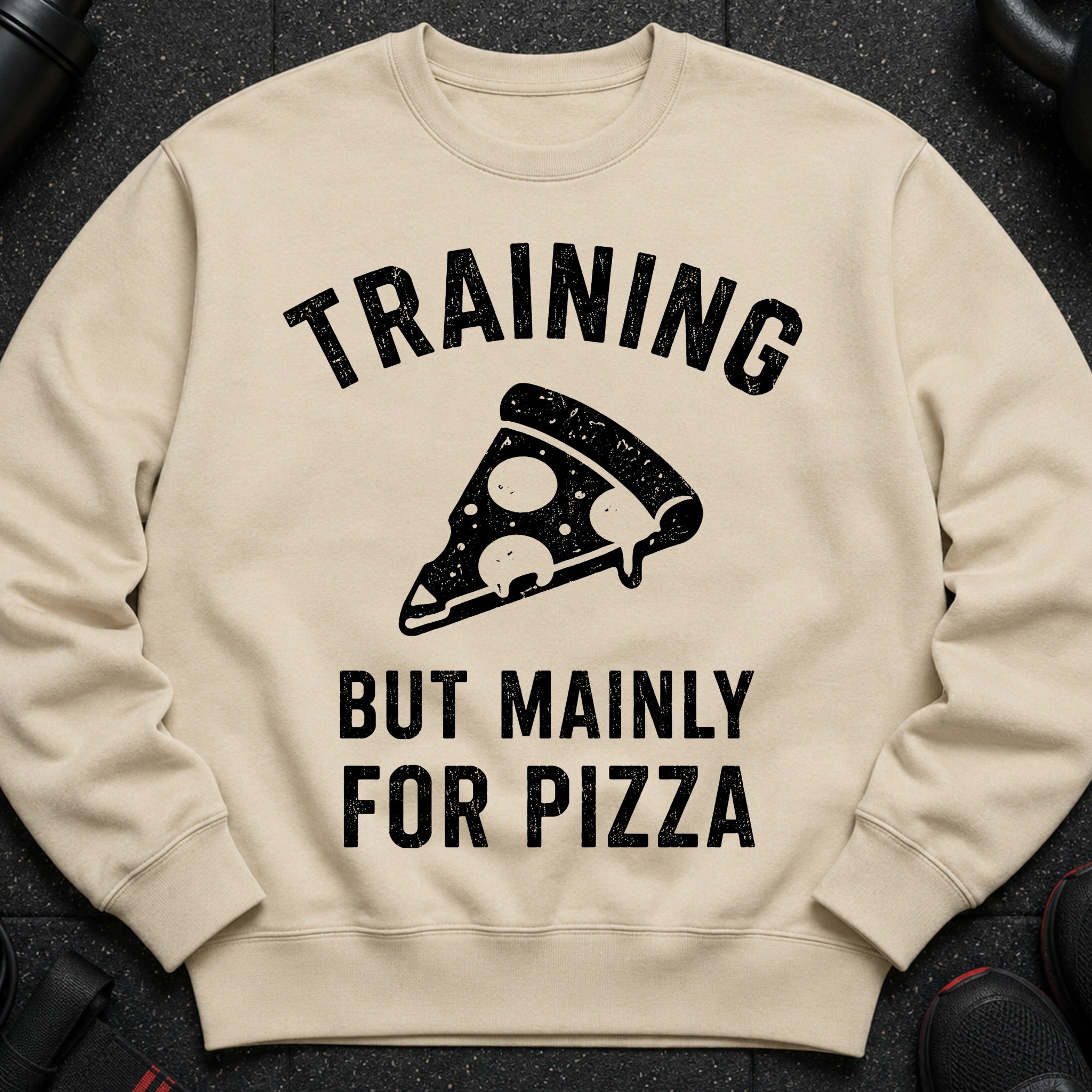Light tan sweatshirt with "TRAINING BUT MAINLY FOR PIZZA" text and a pizza slice graphic.