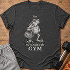 Dark gray t-shirt with a graphic of a frog wearing a hoodie and carrying a gym bag, with text.