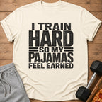 Cream t-shirt with black text reading "I TRAIN HARD SO MY PAJAMAS FEEL EARNED".