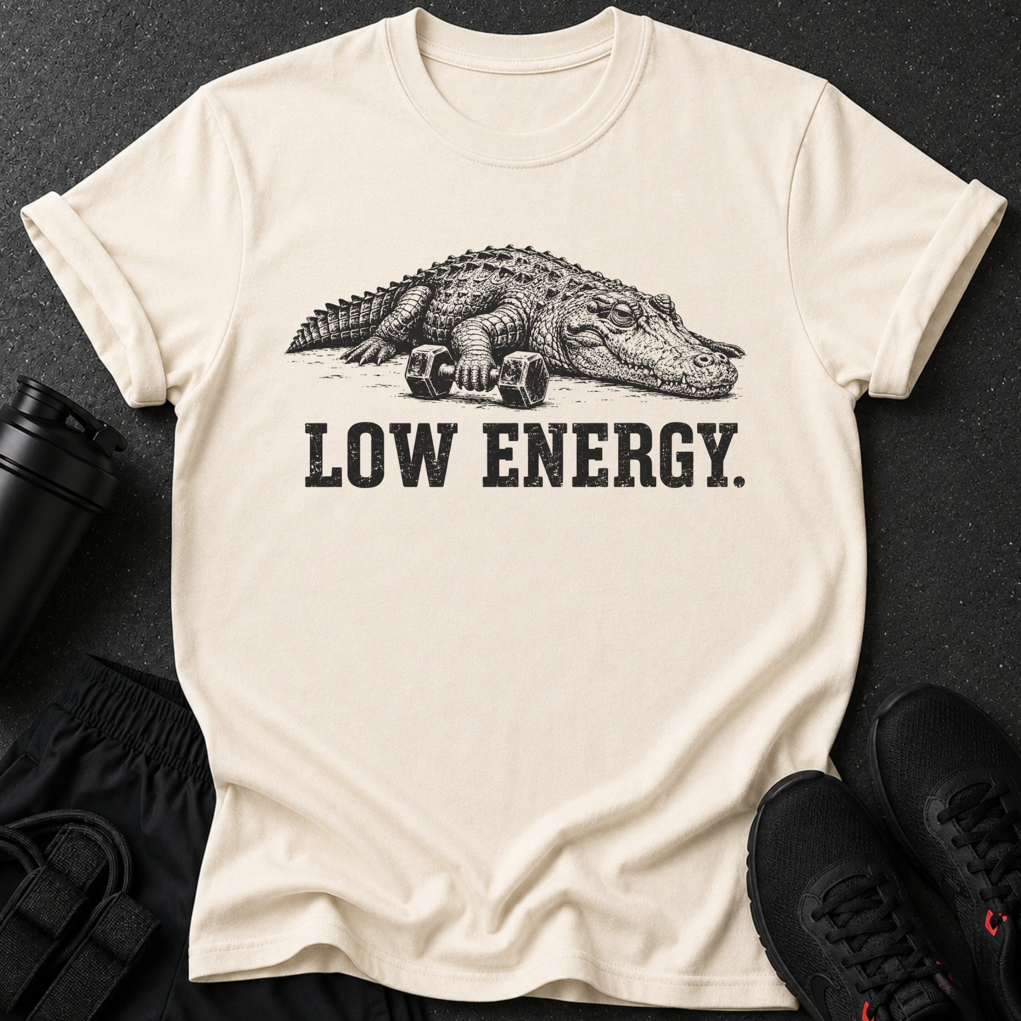 Cream t-shirt with graphic of alligator and dumbbells, text "LOW ENERGY."