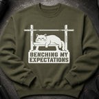 Green sweatshirt with white graphic of a grumpy cat on a weight bench and text.
