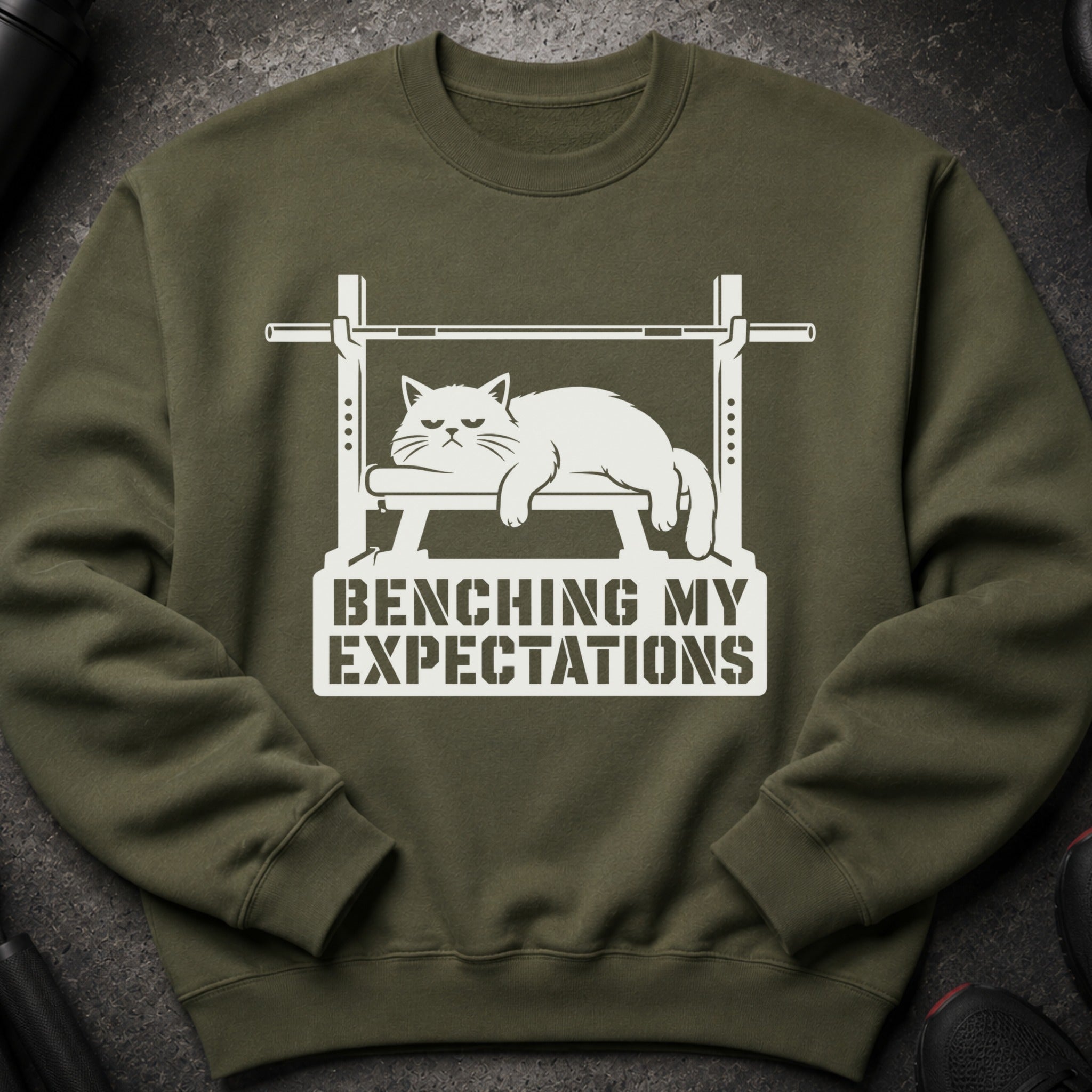 Green sweatshirt with white graphic of a grumpy cat on a weight bench and text.