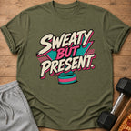 Olive green t-shirt with "SWEATY BUT PRESENT." graphic, sweatpants, dumbbell, and pizza.