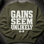Olive green sweatshirt with white distressed text "GAINS SEEM UNLIKELY" and a dumbbell graphic.