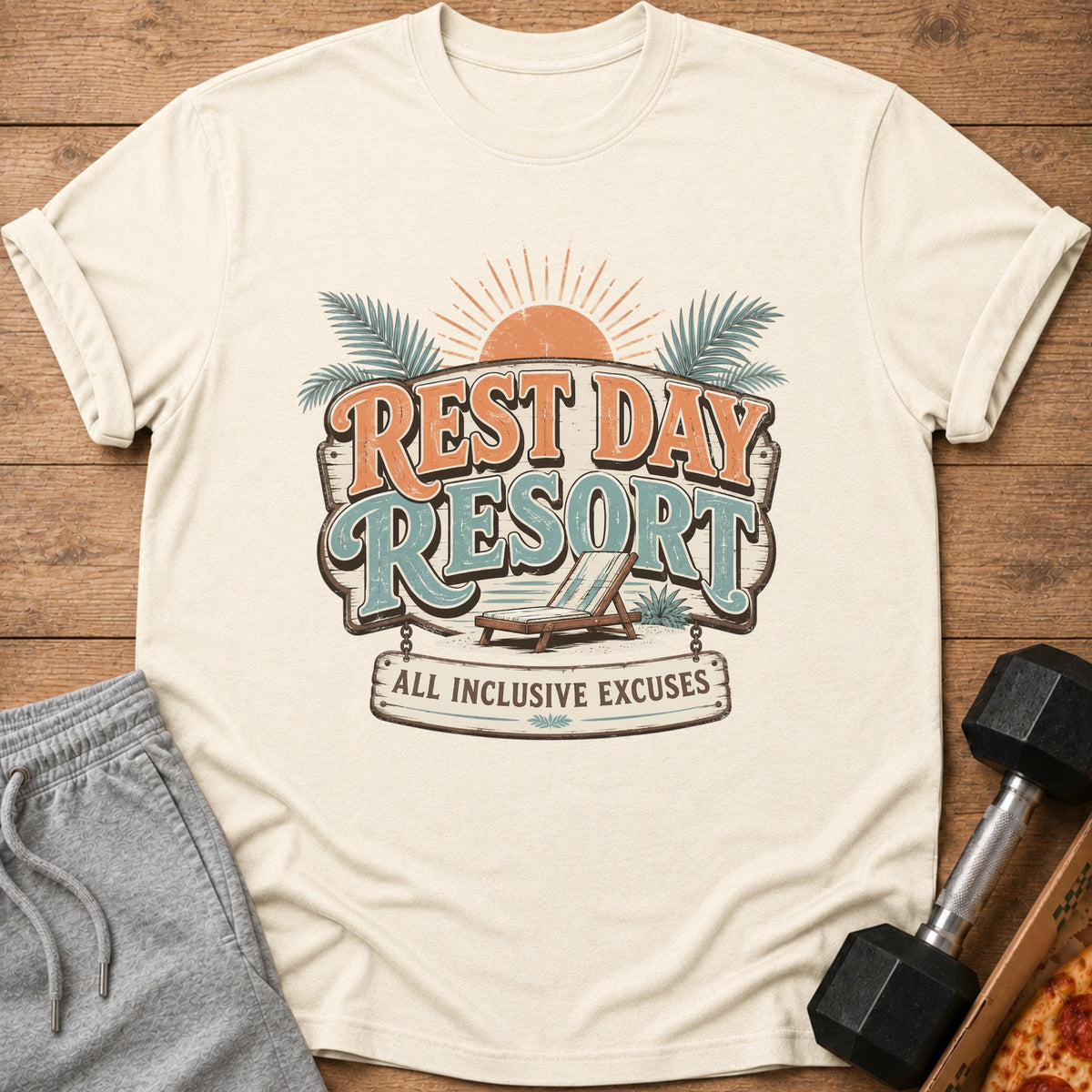 Cream t-shirt with "Rest Day Resort All Inclusive Excuses" graphic and beach chair.