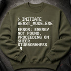 Olive green sweatshirt with white pixelated text: "> INITIATE BEAST_MODE.EXE ERROR: ENERGY NOT FOUND. PROCEEDING ON SHEER STUBBORNNESS."