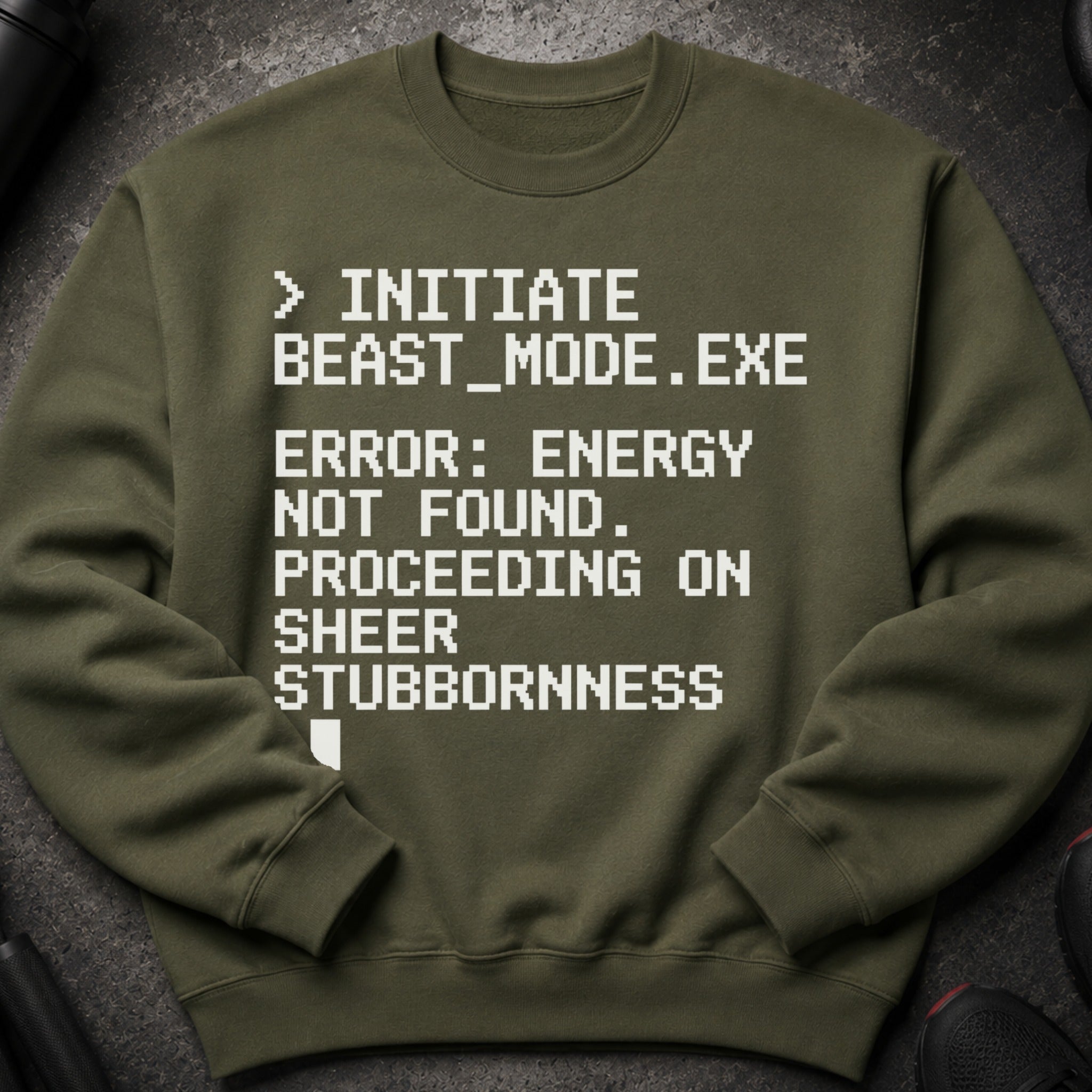 Olive green sweatshirt with white pixelated text: "> INITIATE BEAST_MODE.EXE ERROR: ENERGY NOT FOUND. PROCEEDING ON SHEER STUBBORNNESS."