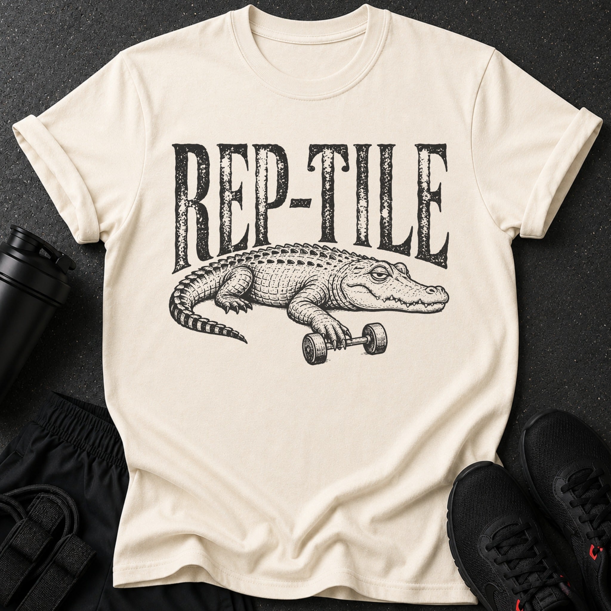 Cream t-shirt with black "REP-TILE" text and alligator lifting dumbbell graphic.